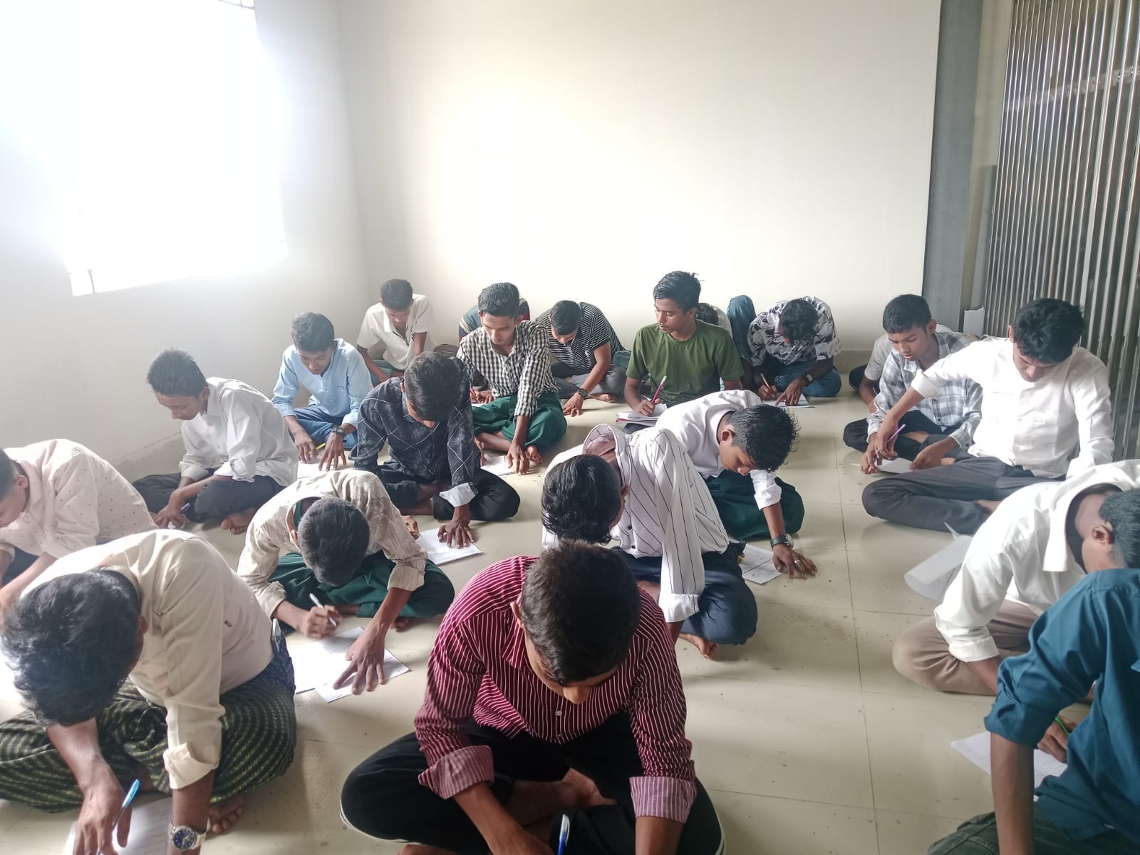 Group of students seated together writing notes during a lesson